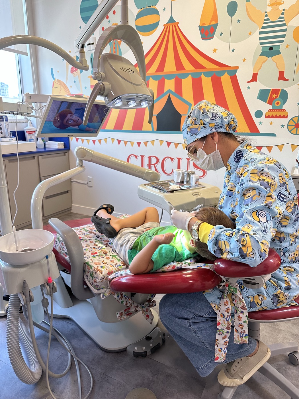 Criança escovando os dentes do pelúcia durante consulta